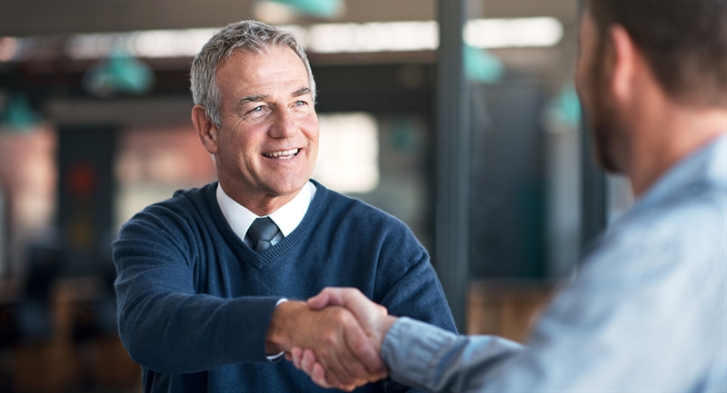 2 business men shaking hands over a business partnership